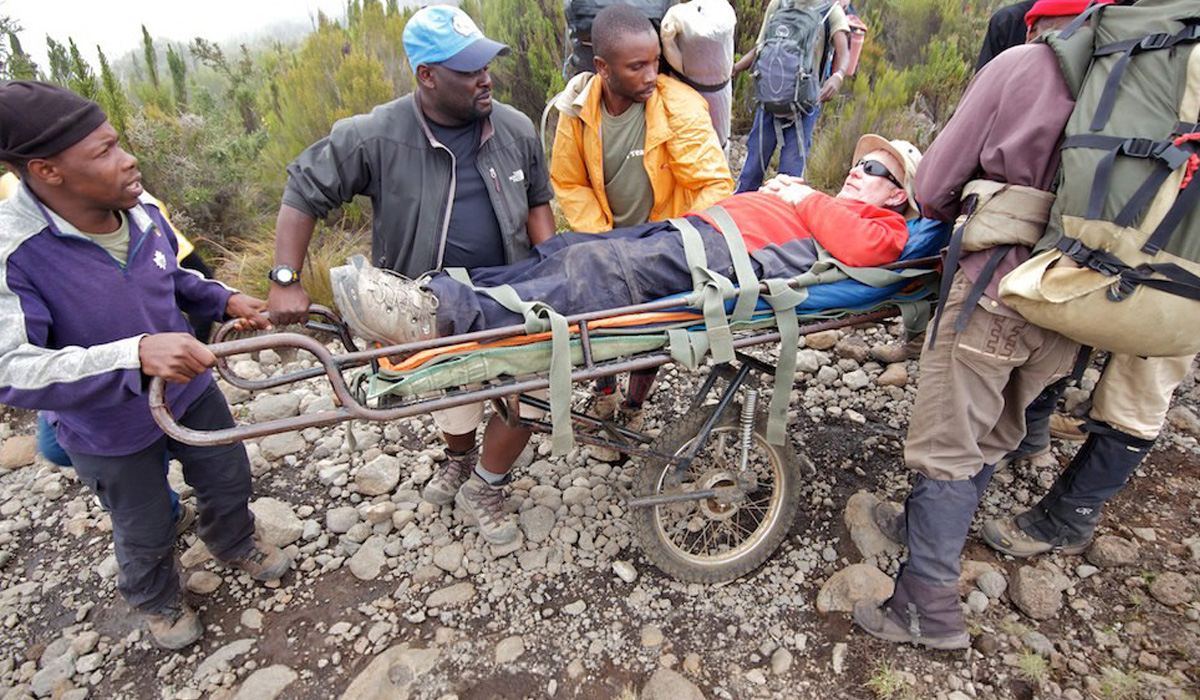 Man on stretcher being rescued from Mt. Kilimanjaro