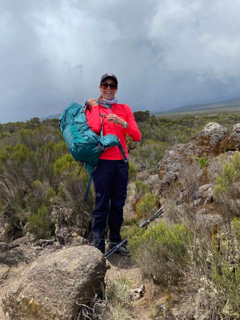 Woman lifting her backpack in the Moorlands section of Mt. Kilimanjaro.