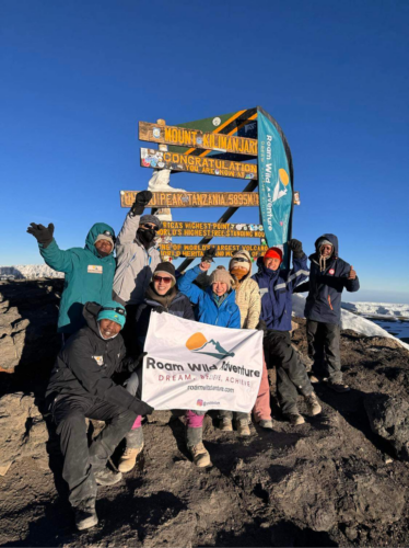 group of climbers celebrating their summit of Mount Kilimanjaro